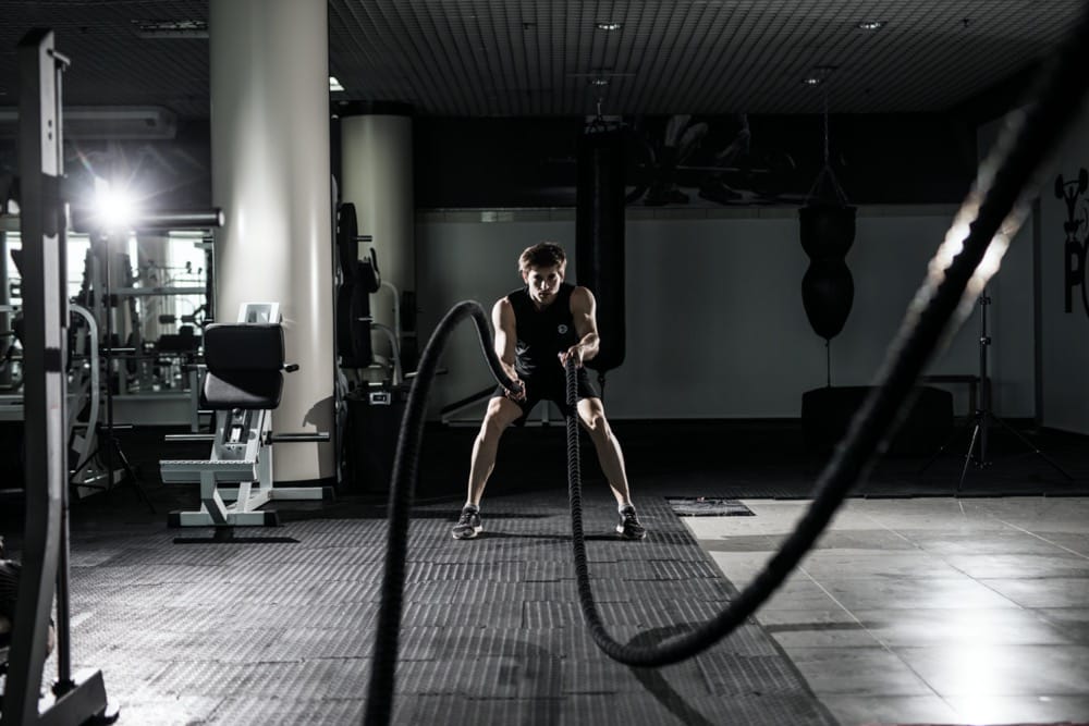Mężczyzna ćwiczący na linach w siłowni — trening zawieszany TRX