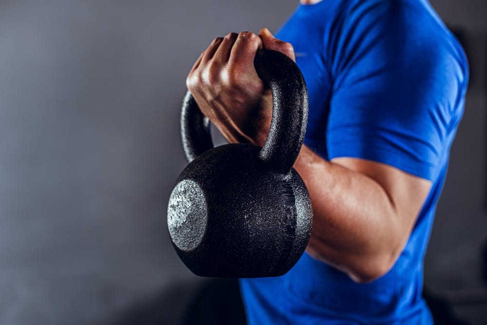 Mężczyzna trzymający kettlebell — trening z odważnikiem